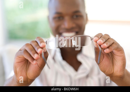 Man holding a pair of glasses. Stock Photo