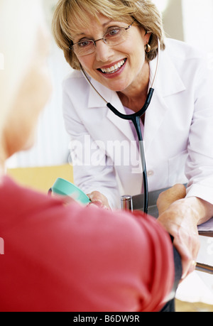 Blood pressure measurement. Sphygmomanometer and stethoscope being used by a doctor to measure a 63-year-old woman's BP. Stock Photo