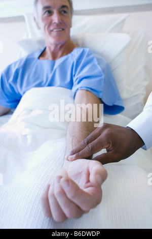Checking pulse. Doctor using his fingers to feel a patient's pulse. Stock Photo