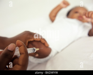 Childhood injection.12-week-old baby girl about to receive an injection. Stock Photo