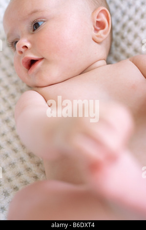 Baby girl. 4-month-old baby girl lying on her back. Stock Photo
