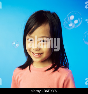 Bubbles. 6 year old girl surrounded by soap bubbles. Stock Photo