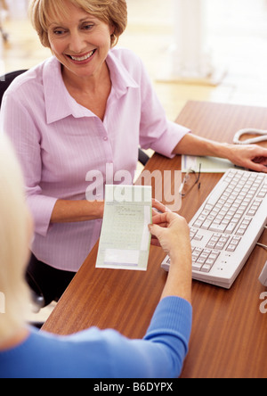 Prescription. 63-year-old woman holding a prescription given to her by her doctor. Stock Photo