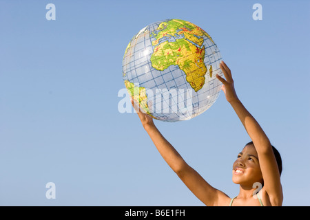 Girl holding an inflated globe. Stock Photo