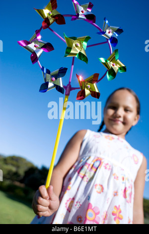 Girl playing. Young girl holding a toy windmill. Stock Photo