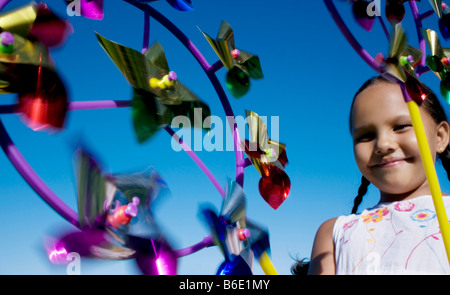 Girl playing. Young girl holding a toy windmill. Stock Photo