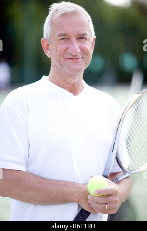 Tennis player. Man holding a tennis racquet and balls. Stock Photo