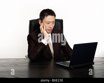 Stressed businessman working on laptop Stock Photo
