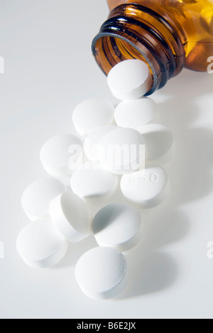 Aspirin pills tipped out of a bottle. Aspirin isan analgesic (painkiller). Stock Photo