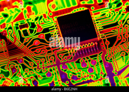 Microprocessor chip (black, upper right) in acircuit board, computer artwork. Stock Photo