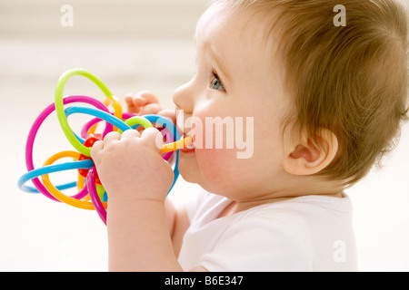 Baby girl chewing on teething ring Stock Photo