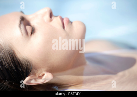 Woman relaxing in a swimming pool Stock Photo