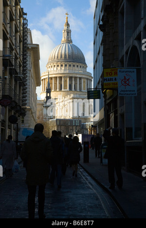 Saint Pauls cathedral in London with city workers walking in street in the darkened forground. Stock Photo