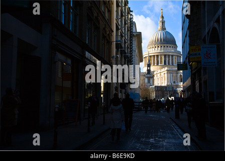 Saint Pauls cathedral in London with city workers walking in street in the darkened forground. Stock Photo