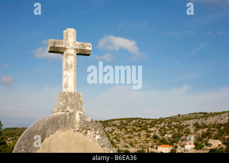 white stone cross on blue sky and cloudy background Stock Photo