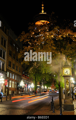 Steam clock in Gastown Vancouver at night with the Harbour Centre Lookout tower British Columbia Canada Stock Photo