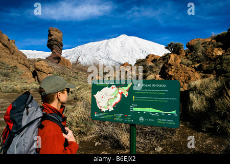 Spain. Canary Islands. Tenerife. National Park called TEIDE. Woman hiking and reading map with El Teide volcano  in background. Stock Photo