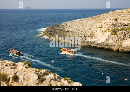 Tourists travelling in small boats to the Blue Grotto, Wied Iz Zurrieq, Malta Stock Photo