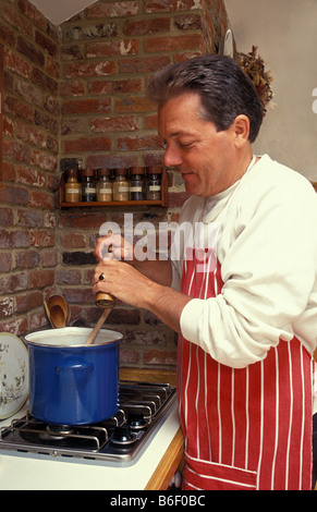 middle aged man cooking in country kitchen Stock Photo