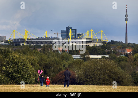 father and his kids flying a kite in front of Signal Iduna Park, Germany, North Rhine-Westphalia, Ruhr Area, Dortmund Stock Photo
