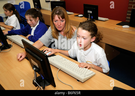 Teacher and pupils in computer studies classroom primary school children Stock Photo