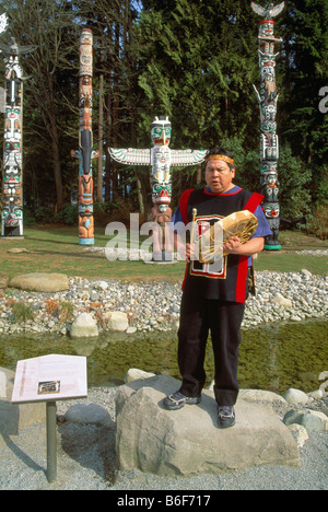 Native Indian drumming at a Ceremony at the Totem Poles at Brockton Point in Stanley Park in Vancouver British Columbia Canada Stock Photo