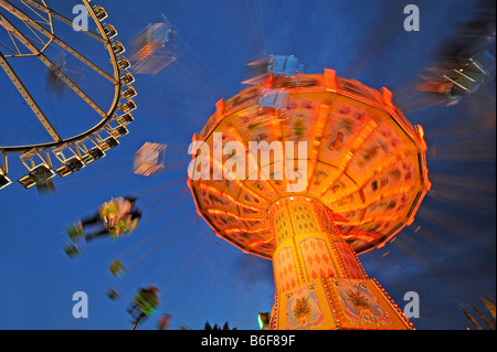 Night shot of swing carousel and big wheel, Cannstatter Volksfest, Stuttgart, Baden-Wuerttemberg Stock Photo