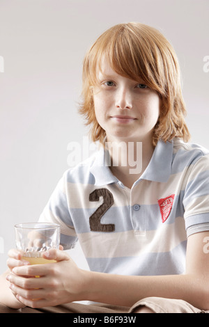 12 year-old boy holding a glass of juice Stock Photo
