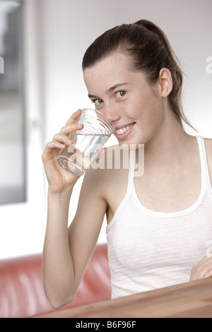 17 year-old girl drinking from a glass of water Stock Photo