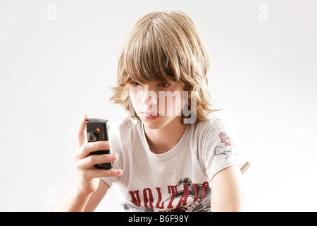 12 year-old boy playing with his cellphone Stock Photo