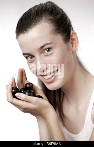 Teenage girl, woman, 17 year-old, holding grapes Stock Photo