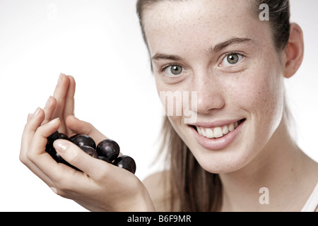Teenage girl, woman, 17 year-old, holding grapes Stock Photo