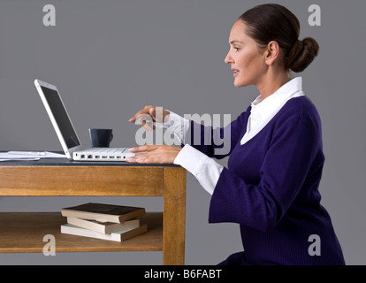 Young woman typing on the keyboard of her laptop Stock Photo