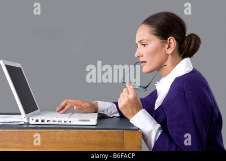 Young woman typing on the keyboard of her laptop Stock Photo