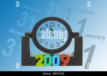 Alarm clock count down to 12 mid night and pages of calendar showing Dec 31 and Jan 1 Stock Photo