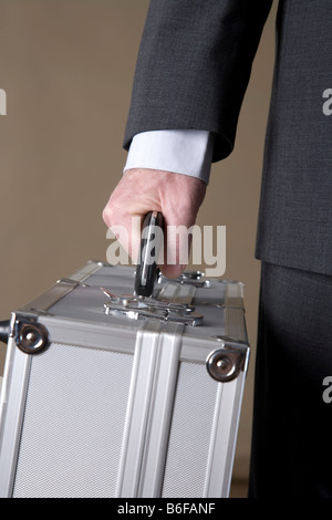 Hand of a businessman holding a metal case Stock Photo