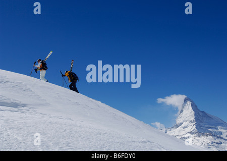 Skiers, Freeriders carrying skis on the Gifthittli, Mount Matterhorn, Zermatt, Wallis, Switzerland, Europe Stock Photo