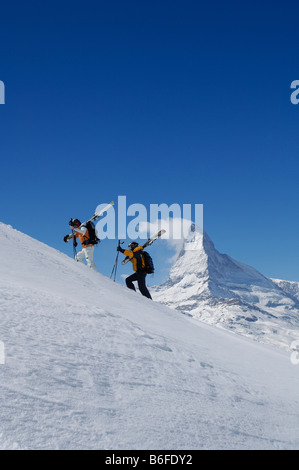 Skiers, Freeriders carrying skis on the Gifthittli, Mount Matterhorn, Zermatt, Wallis, Switzerland, Europe Stock Photo