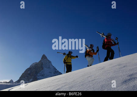 Back country skiers, freeriders, hiking over the Sandiger Boden ski area in front of the Matterhorn Mountain, Zermatt, Valais o Stock Photo