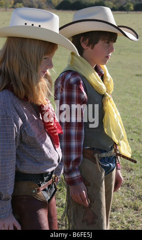 A young cowgirl and cowboy looking over the cattle ranch Stock Photo
