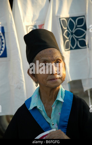 Old woman wearing traditional dress of Hmong ethnic, selling cloth at the night market, Luang Prabang, Laos Stock Photo