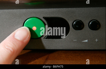 Finger pushing a standby button on a television, Regensburg, Bavaria, Germany, Europe Stock Photo