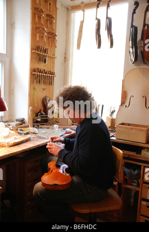 Luthier, violin maker in his workshop Stock Photo