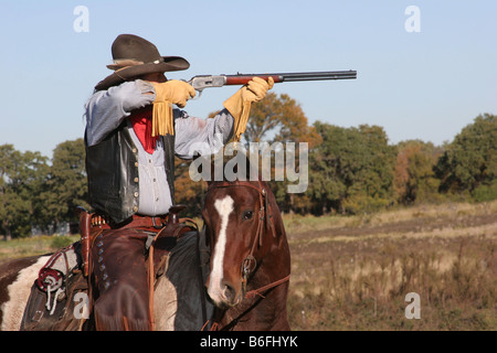 A cowboy on horseback taking aim Stock Photo