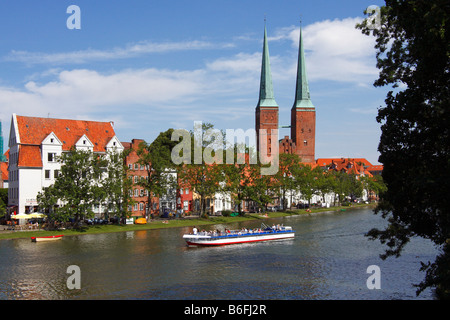 Pleasure boat on the Trave river, Luebeck cathedral, cathedral in the old hanseatic city of Luebeck and the An der Obertrave st Stock Photo