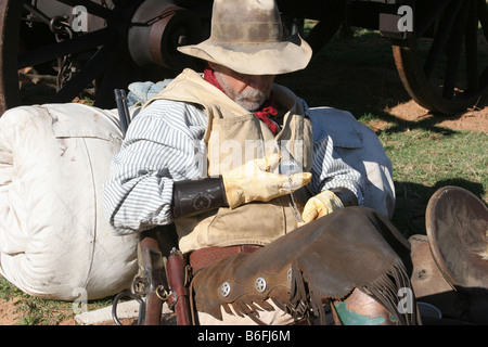 a cowboy checking his pocket watch for the time Stock Photo