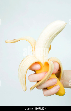 Peeled banana in hand Stock Photo