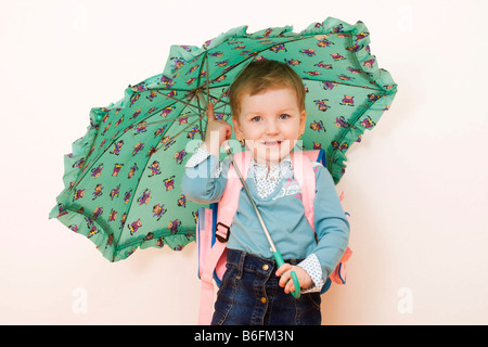 Little girl, 3 years, with umbrella and schoolbag Stock Photo