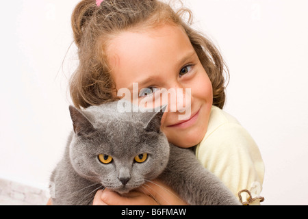 Girl, 6 years old, with British Shorthair cat, blue