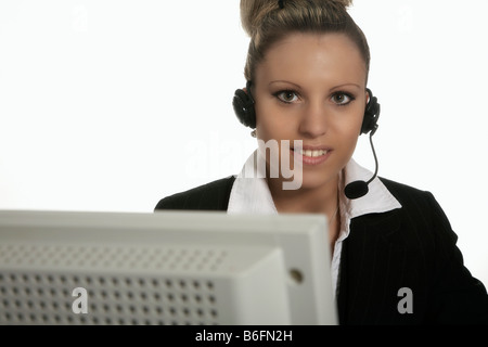 Businesswoman wearing a headset working at a PC Stock Photo